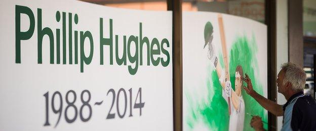 A portrait is painted on a store display in memory of Australian cricketer Phillip Hughes.