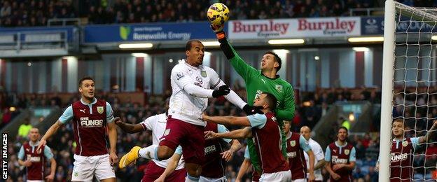 Burnley keeper Tom Heaton punches the ball away from Villa's Gabriel Agbonlahor