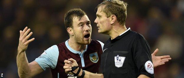 Ashley Barnes argues with referee Graham Scott