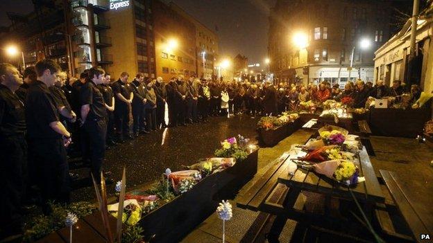 Members of the emergency services and the public hold a minute's silence outside the Clutha in Glasgow