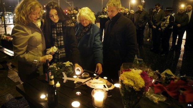 Members of the emergency services and the public hold a minute's silence outside the Clutha in Glasgow