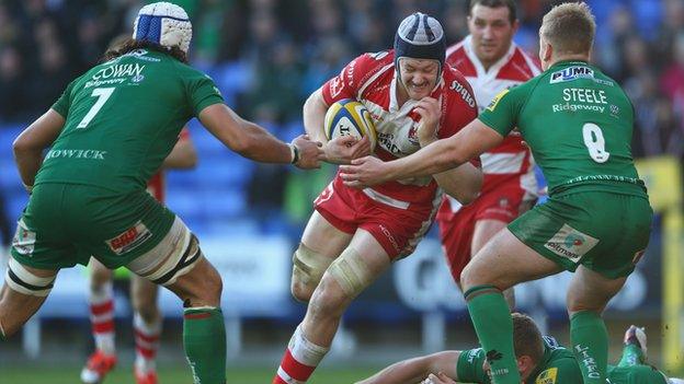 Tom Savage (C) of Gloucester charges at Blair Cowan (L) and Scott Steele (R) of London Irish