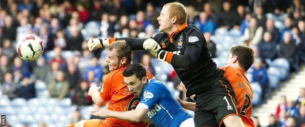 Rangers sub Nicky Clark is outnumbered as Craig Samson punches the ball clear