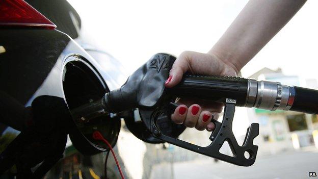 Hand on petrol pump filling up car