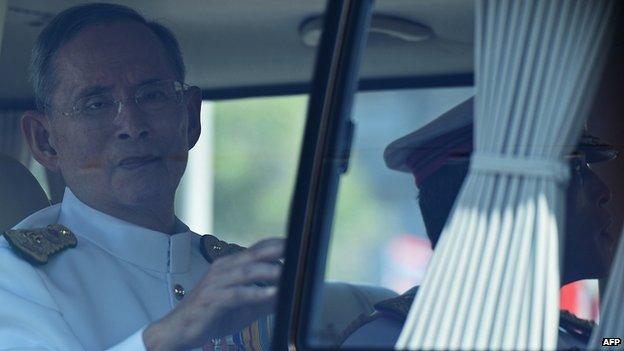 Thailand's King Bhumibol Adulyadej waves to a crowd of well-wishers as he travels in a motorcade to the Royal Palace to mark the 64th anniversary of his coronation in Hua Hin (5 May 2014)