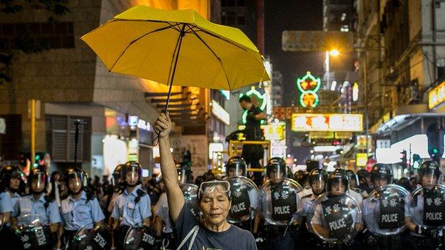 Hong Kong protester stands in front of police