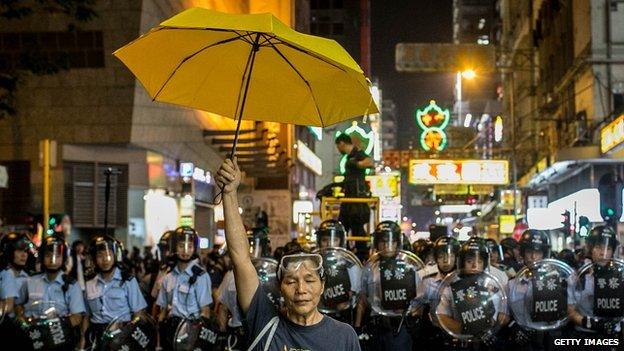 Hong Kong protester stands in front of police