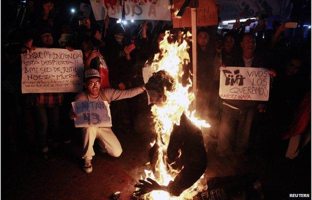 Demonstrators burn an effigy of Mexico's President Enrique Pena Nieto during a protest in support of the 43 missing trainee teachers in Tijuana on 1 December , 2014