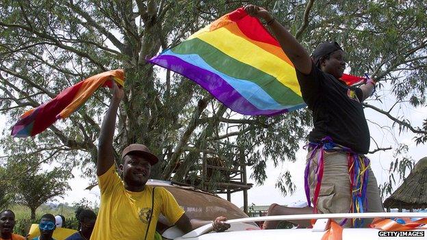 Ugandans wave a rainbow flag at a gay pride rally in Entebbe (file pic Aug 2014)