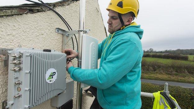 An engineer fits an antenna to a house