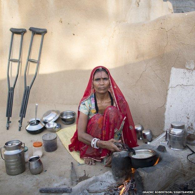 Manju cooking, her crutches are propped up against the wall