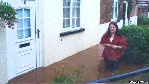 Susan Dawson in floods outside her home