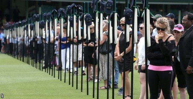 Mourners gather for a memorial service at the Sydney Cricket Ground and look at 63 bats with inscriptions detailing the career of Phillip Hughes