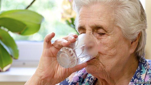 Elderly woman drinking water