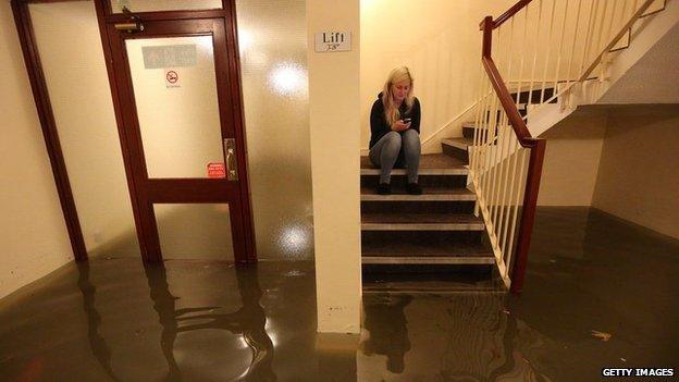 Woman on phone in flooded Boston flat