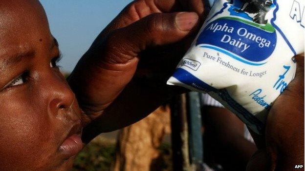 A young boy looks at a milk packaging from Alpha Omega Dairy, a brand launched by Zimbabwean First Lady Grace Mugabe, in a supermarket in Harare, on 11 July 2012