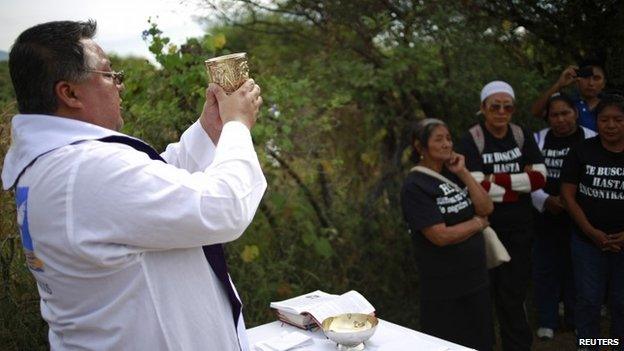 Priest Oscar Mauricio Prudenciano officiates a mass for people with missing relatives before a search in an area thought to contain mass graves in La Joya, outside Iguala in Guerrero state on 29 November 2014.