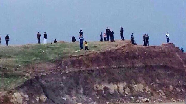 People gather on a hill in Mosul