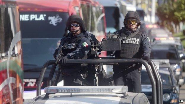 Mexican federal policemen patrol a street in Acapulco on 3 December, 2014.