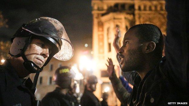 A New York Police officer stands near a man protesting the Eric Garner grand jury's decision.