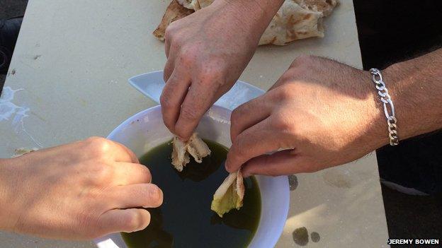 Bread is dipped into olive oil from olives grown on the West Bank