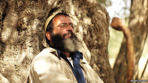 Salah Abu Ali in the shade of one of the oldest olive trees in Palestine