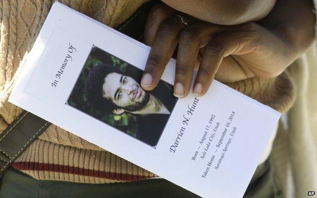 A family friend holds the funeral programme for Darrien Hunt following his funeral on 18 September 2014, in Saratoga Springs, Utah