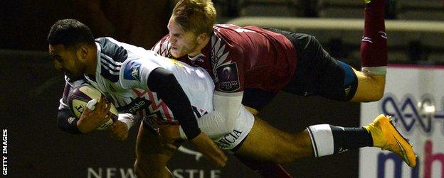 Krisnan Inu (l) tackled by Chris Harris