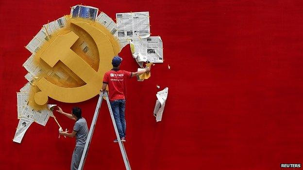 Workers repaint hammer and sickle symbol of Chinese Communist Party flag at Nanhu Revolutionary Memorial museum in Jiaxing, Zhejiang province. May 2014