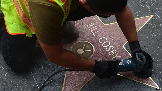 Worker cleans Bill Cosby's star on the Hollywood Walk of Fame on 5 December after it was vandalised