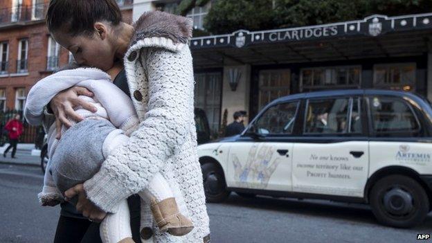 Woman breastfeeds her baby outside Claridge's