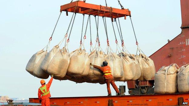 Workers unload goods from a ship at the port in Lianyungang, east China's Jiangsu province