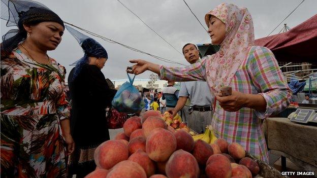 This photo taken on 27 June, 2013 shows Uighur traders at the main bazaar in Turpan, Xinjiang region