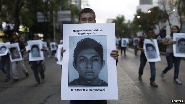 A demonstrator carries a photograph of Alexander Mora Venancio in Mexico City on 6 December December, 2014