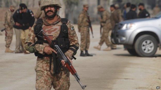 Pakistani army soldiers cordon off the area of a bombing in Peshawar, Pakistan , Nov. 21