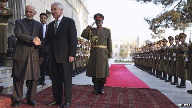 Afghanistan's President Ashraf Ghani shakes hands with US Secretary of Defense Chuck Hagel during an arrival ceremony at the Presidential Palace in Kabul December 6