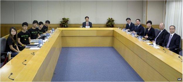 Hong Kong government officials sit opposite to the student leaders from the Hong Kong Federation of Students during a photo call before their talks in Hong Kong Tuesday, 21 October 2014