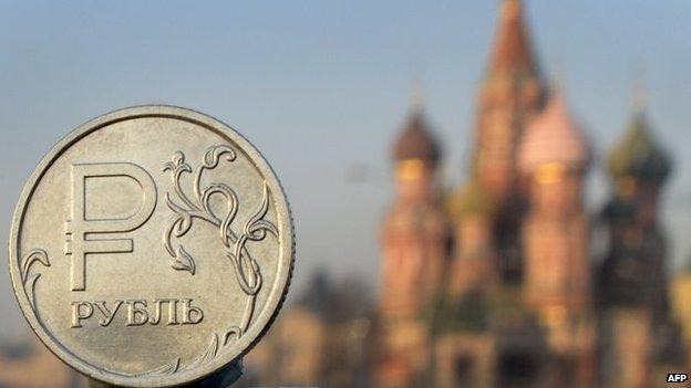 A Russian rouble coin is pictured in front of St. Basil cathedral in central Moscow,