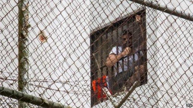 Leopoldo Lopez appears in a window of his cell on 15 November 2014.