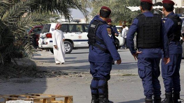 Police stand at the scene of the bombing in Karzakan, Bahrain (9 December 2014)