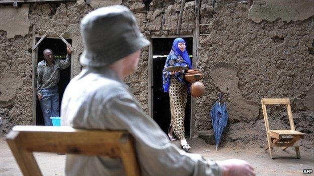 Neema Kajanja, 28, carries on 27 January 2009 ceramic pots she sells for a living from her grandmothers home, where she and two siblings, both albinos, live in Ukerewe