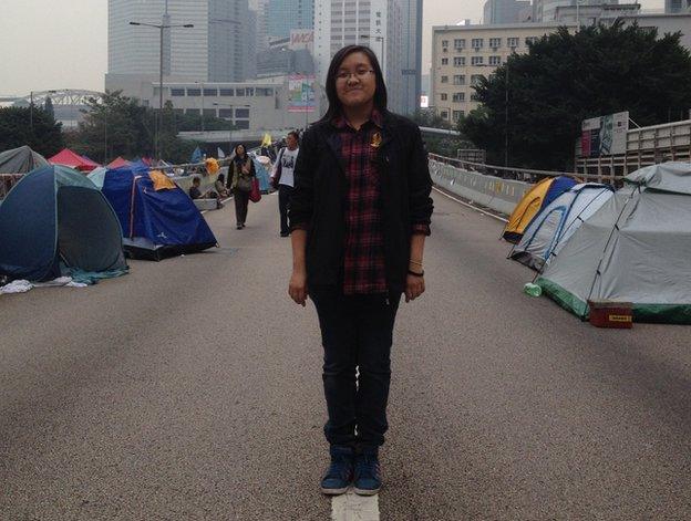 Liona Li stands in the road in a protest camp