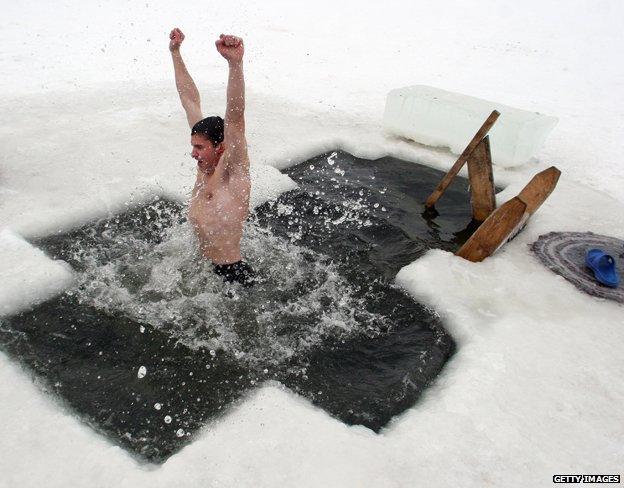 A Belarussian swimmer celebrates the feast of Epiphany by diving into an icy lake