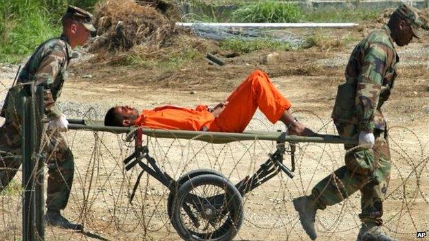 Detainee from Afghanistan being carried to interrogation at Guantanamo Bay, 2002