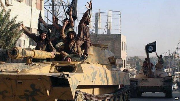 Islamic State fighters drive through the Syrian city of Raqqa on captured tanks (30 June 2014)