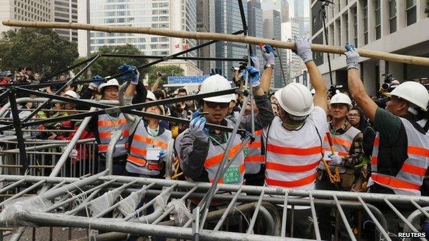 Workers remove a barricade at an area blocked by pro-democracy protesters near the government headquarters building at the financial Central district in Hong Kong on 11 December 2014