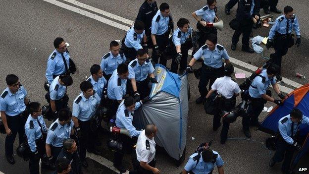 Hong Kong police begin to dismantle the remaining pro-democracy tents set up along a road at the protest camp in the Admiralty district of Hong Kong on 11 December 2014.