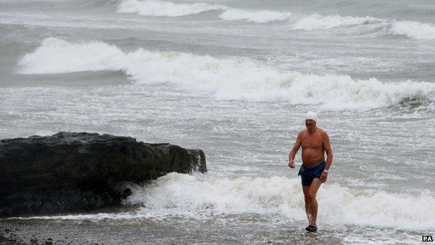 Man walks away from sea on Irish coast