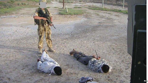 Detained Iraqis being guarded by a British soldier