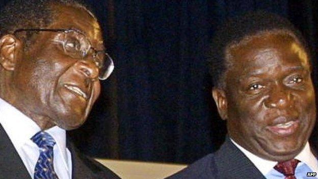 Zimbabwe's President Robert Mugabe (L) talks to Emmerson Mnangagwa on 3 December 2004